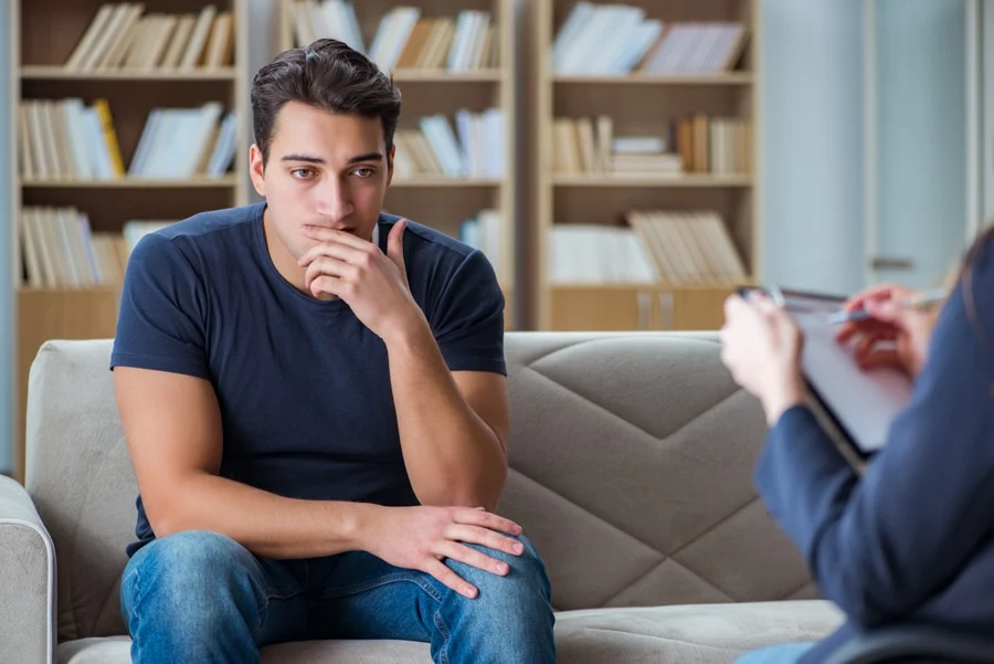 Young man sitting on a couch while receiving cognitive behavioral therapy Young man sitting on a couch while receiving dialectical behavior therapy in Idaho