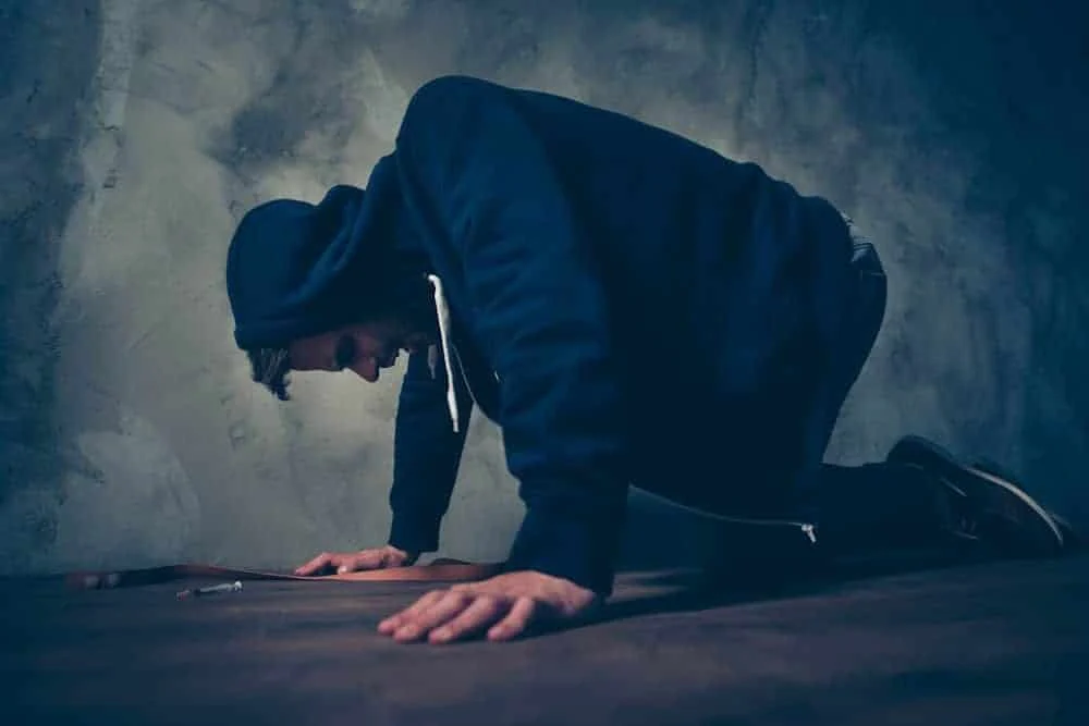 myths-about-meth Man slumped over in hoodie while detoxing from meth