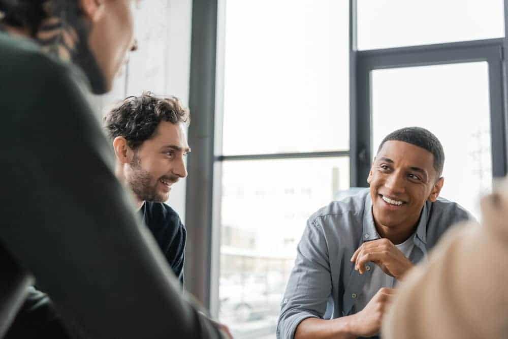 Men chatting in a group in a brightly lit building