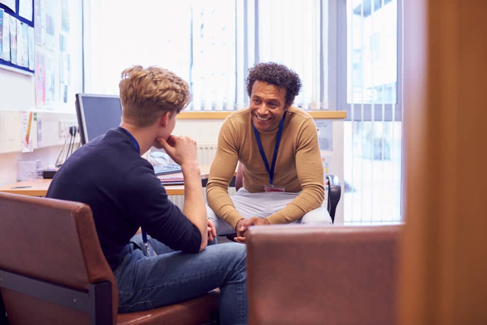 Youth therapist talking to young man with broccoli haircut