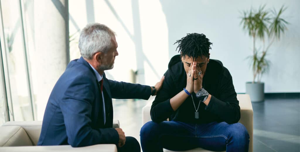 Therapist comforts man suffering with depression