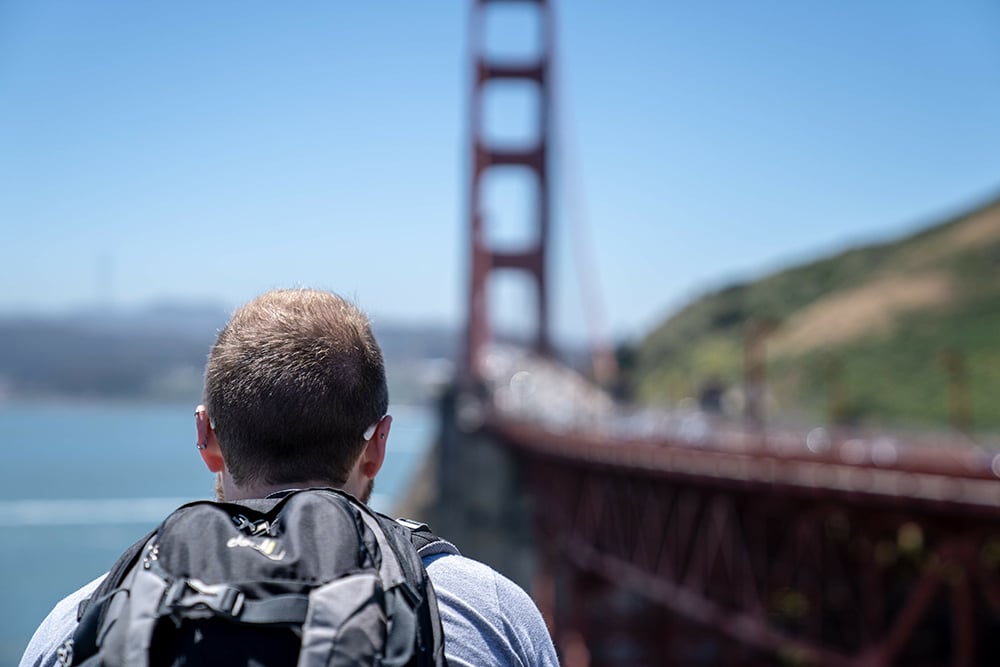 a young man engaging in wilderness therapy program close to a city bridge