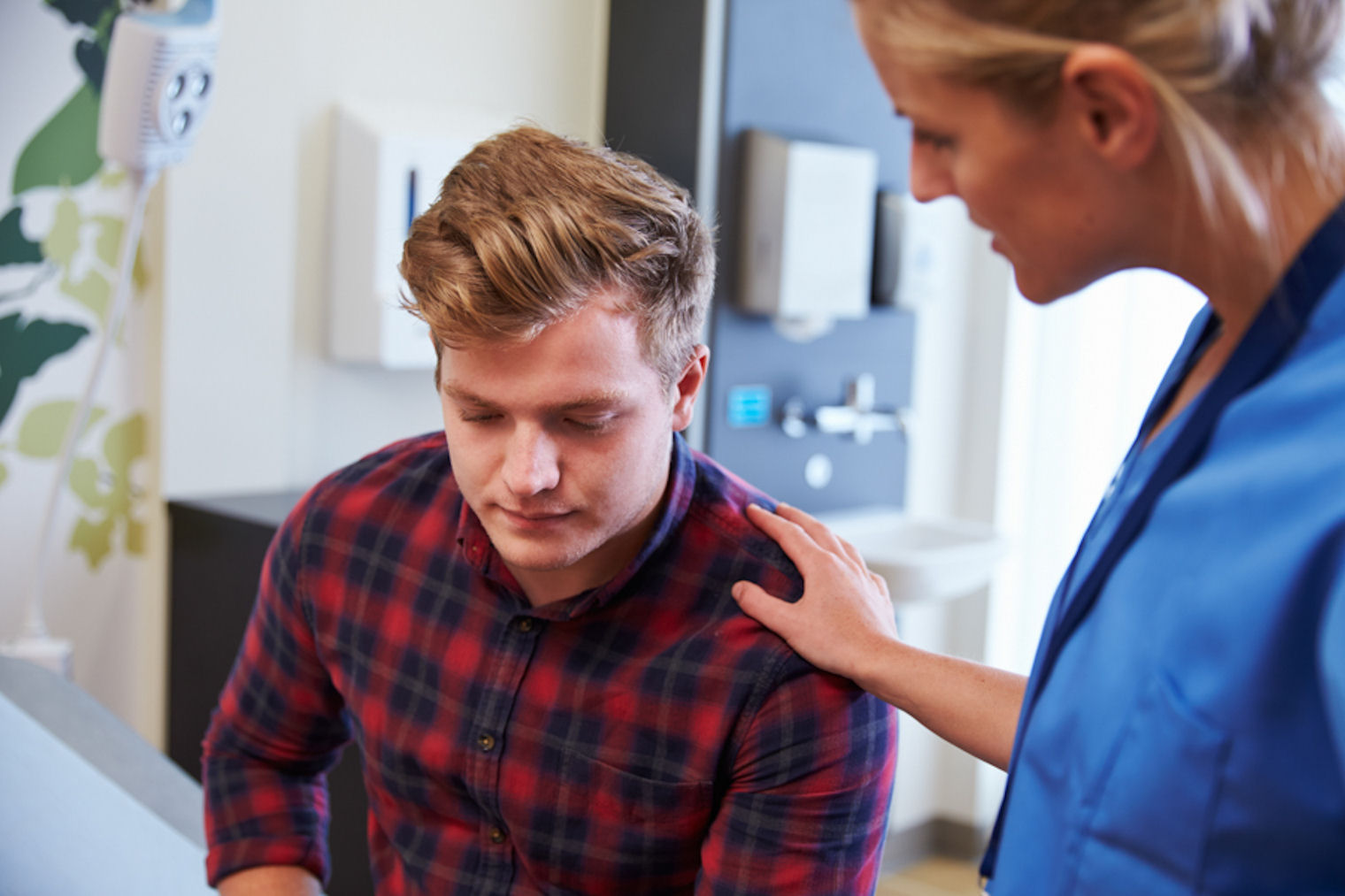 Nurse comforting man hearing news about how stimulant addiction affects the body