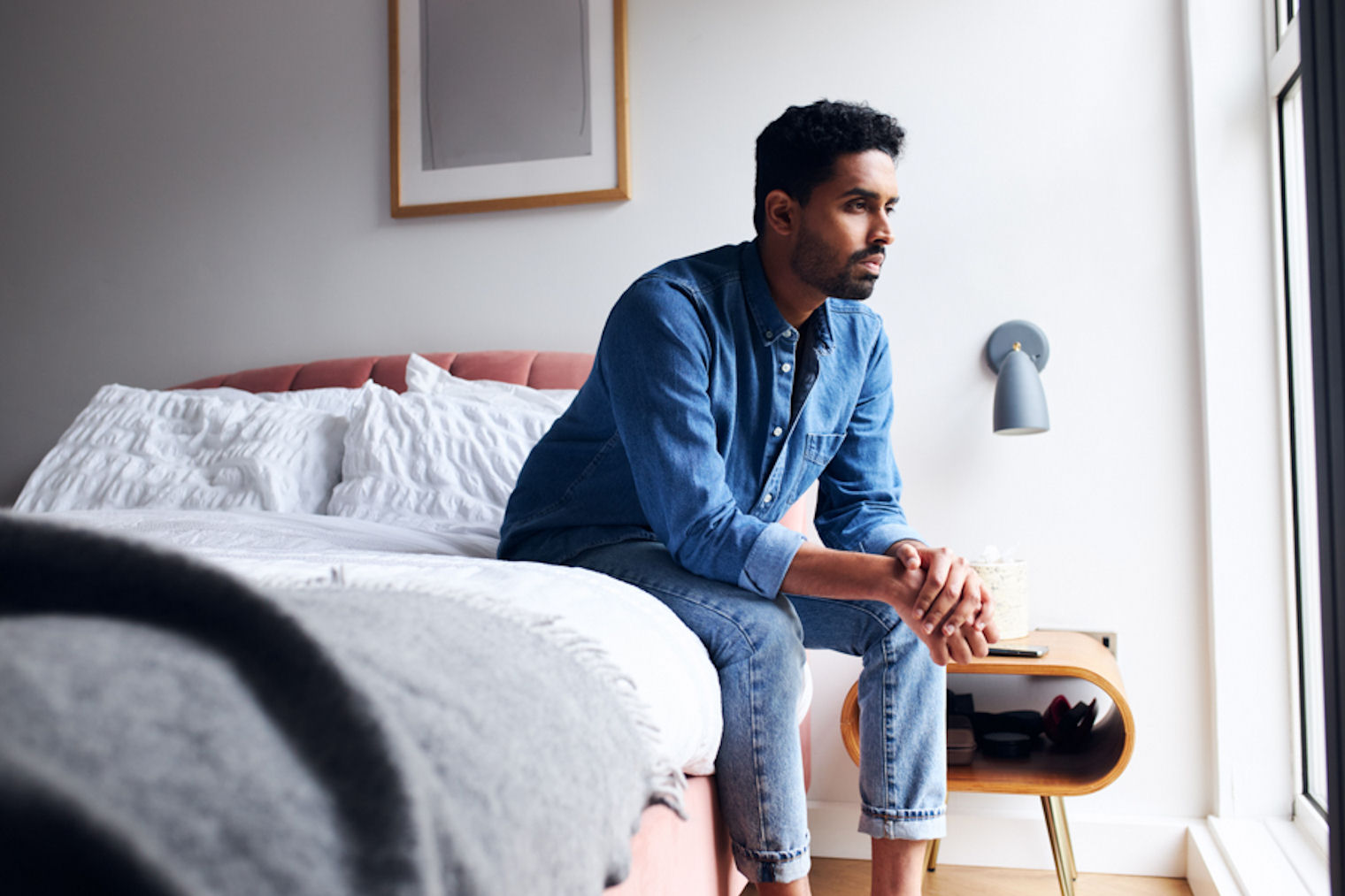 Man sitting on edge of hotel bed while fighting stimulant withdrawal symptoms