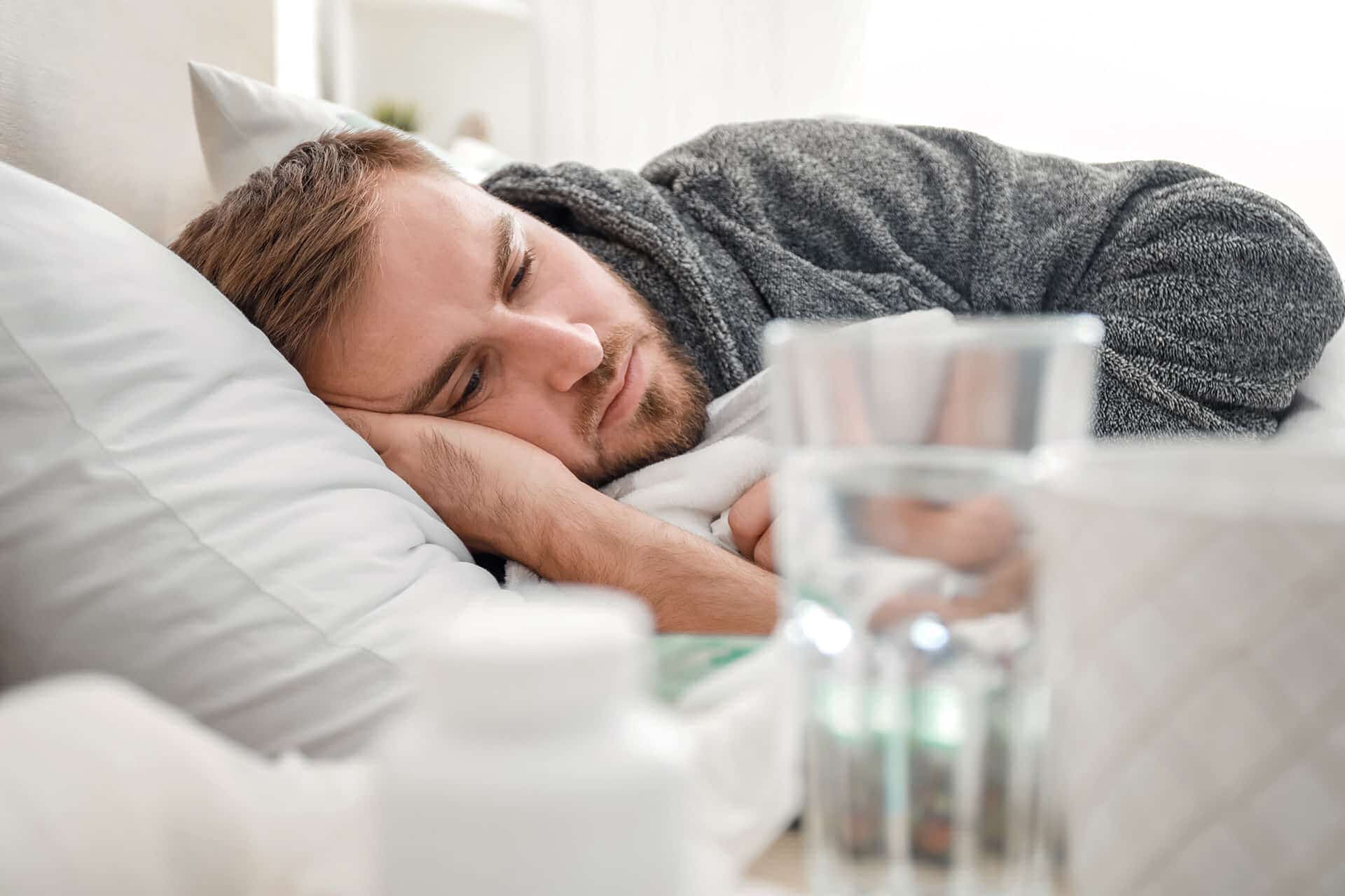 Man lying down while coping with mild symptoms of delirium tremens (DTs)