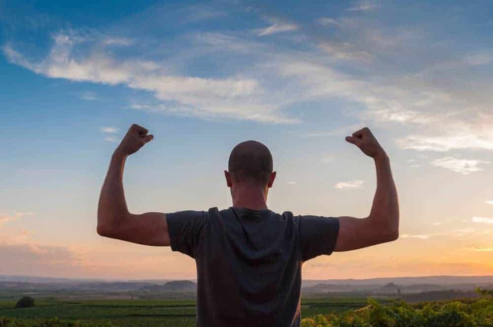 Man with histrionic personality disorder flexing in front of sunset