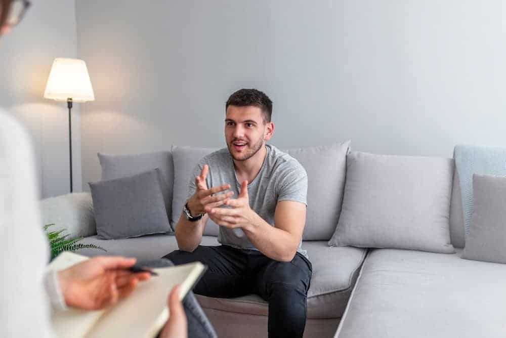 Man describing histrionic personality disorder to therapist while seated on white couch