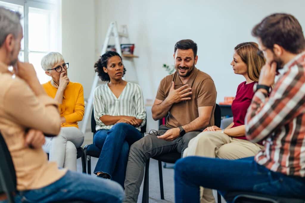 Man opening up to support group about childhood trauma