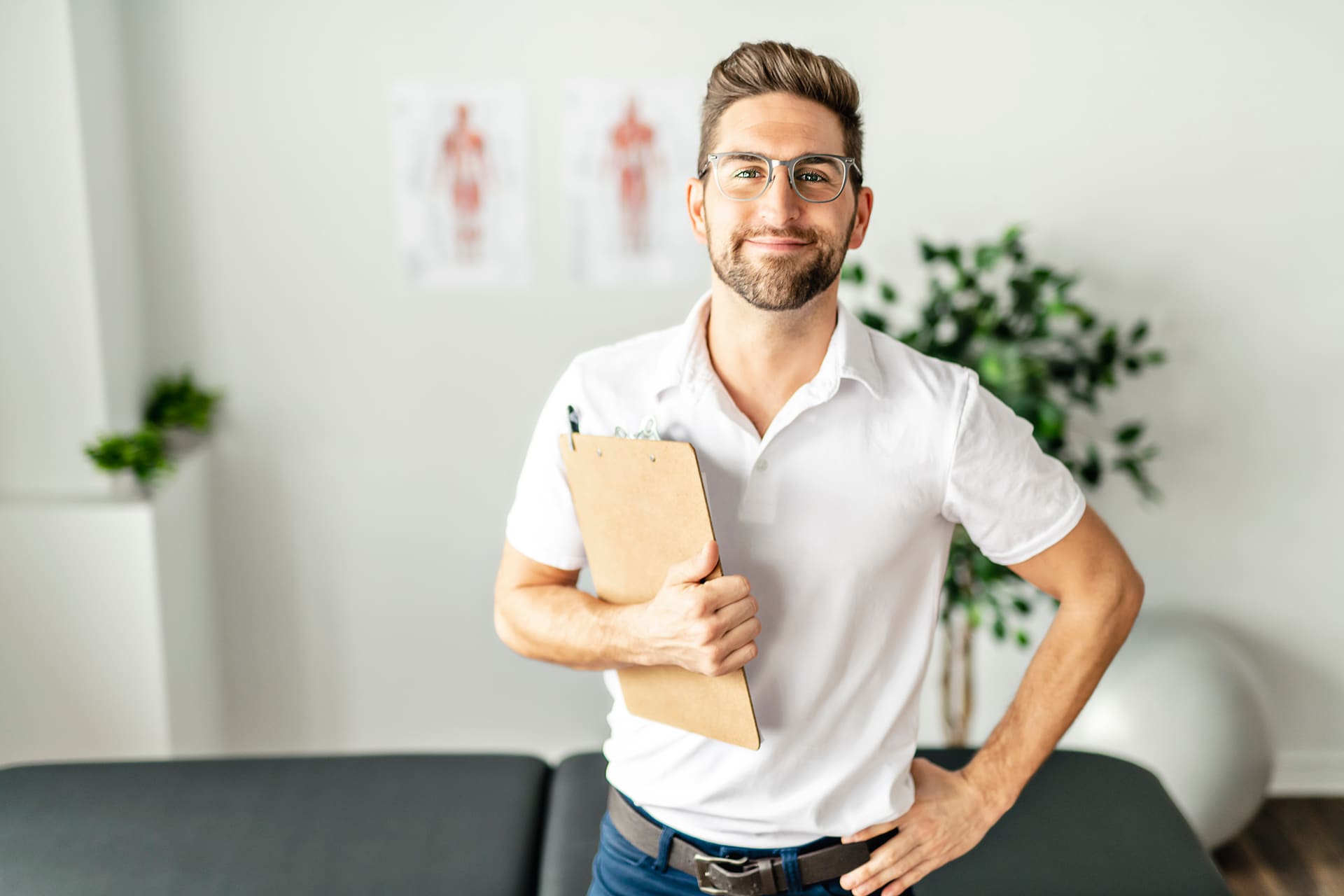 Man with glasses in medical office holding clipboard