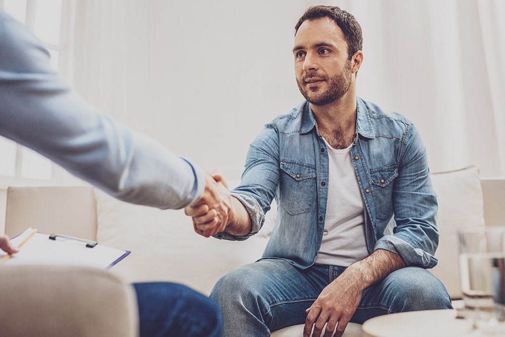 Man shaking hand of doctor while discussing health after quitting alcohol