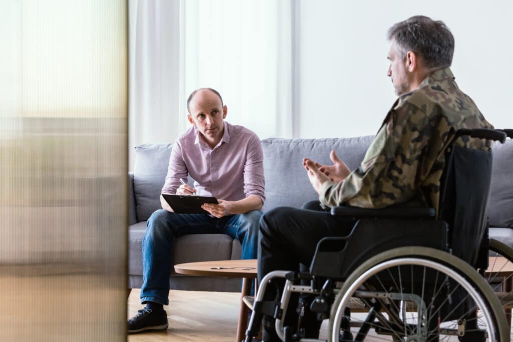 Hero: Man in wheelchair wearing fatigues discussing the most addictive drugs with therapist.