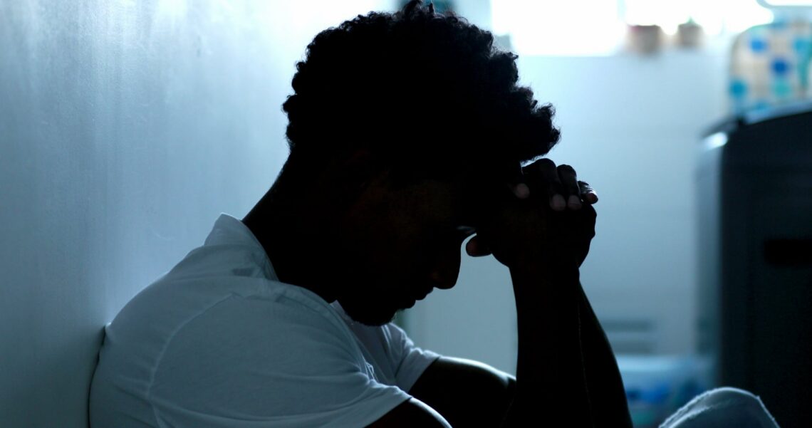 new father holding his head while suffering from clinical depression.