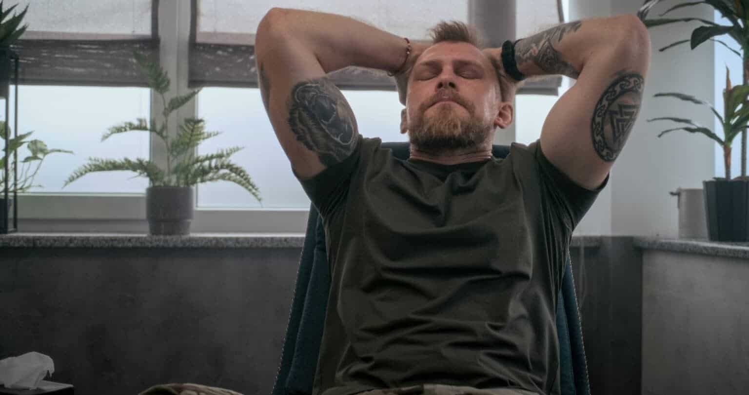 Man lying back with hands behind his head, thinking about addiction replacement.