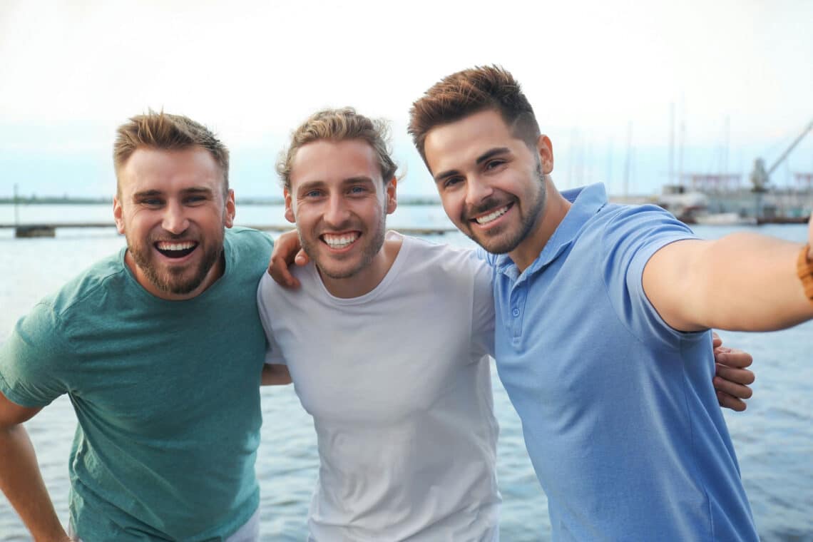 Three men giving each other a side hug