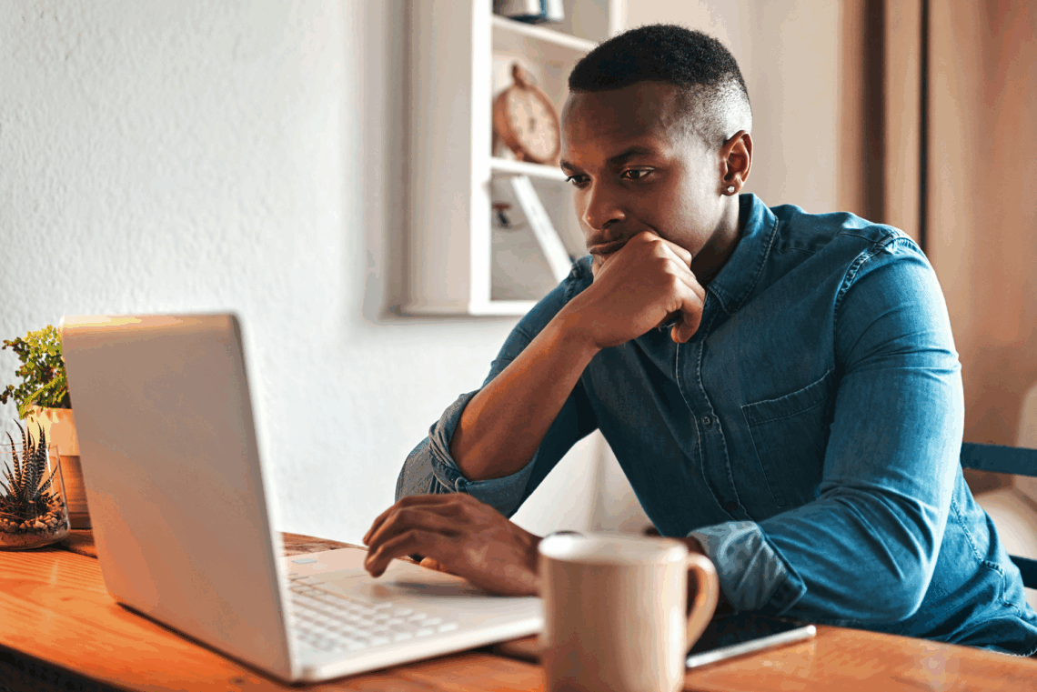 Man researches alcohol and gambling addiction on a laptop.