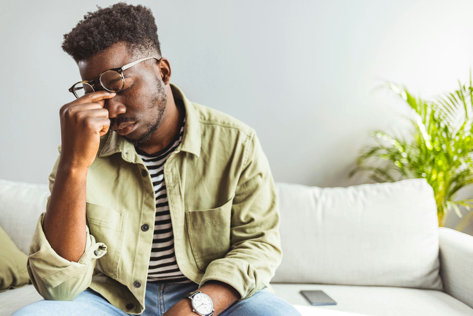 Man leaning over and pinching bridge of nose before mindfulness practice.
