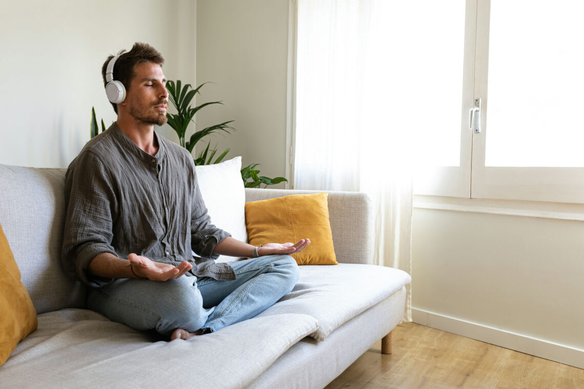 Man quitting alcohol cold turkey meditating with headphones on